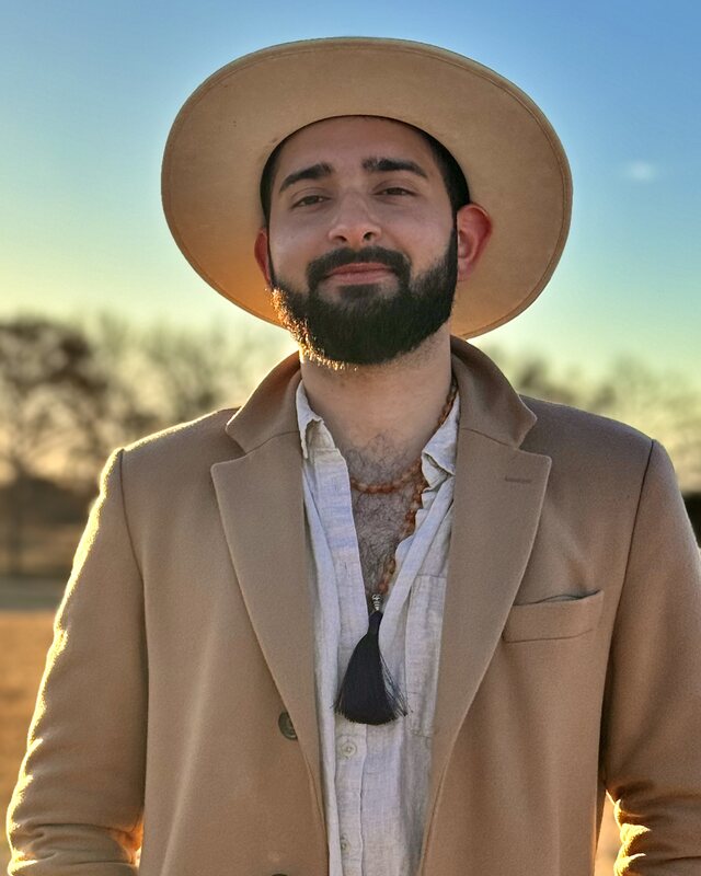 Ennis M. Salam outdoors in a tan coat and hat